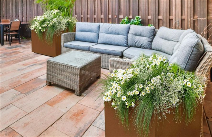 Rust Corten steel rectangular planters with flowering plants decorating outdoor rattan lounge patio space