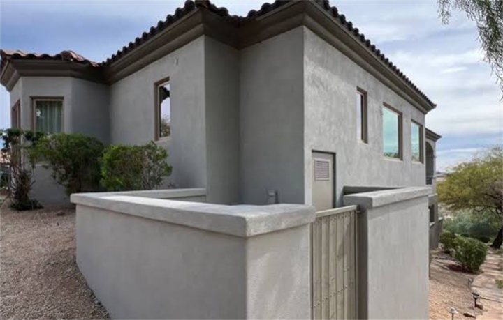 Smooth gray three-coat stucco exterior on southwest-style residential home and retaining walls