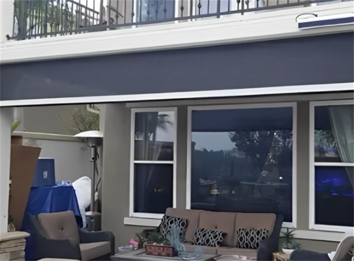 Motorized exterior screen shading a residential covered patio, creating a breezy screened outdoor lounge