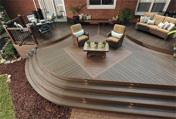 Multi-level curved composite deck featuring diagonal decking patterns creating distinct outdoor seating zones
